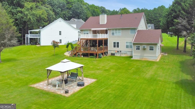 back of property featuring a gazebo, a wooden deck, a yard, and a patio area