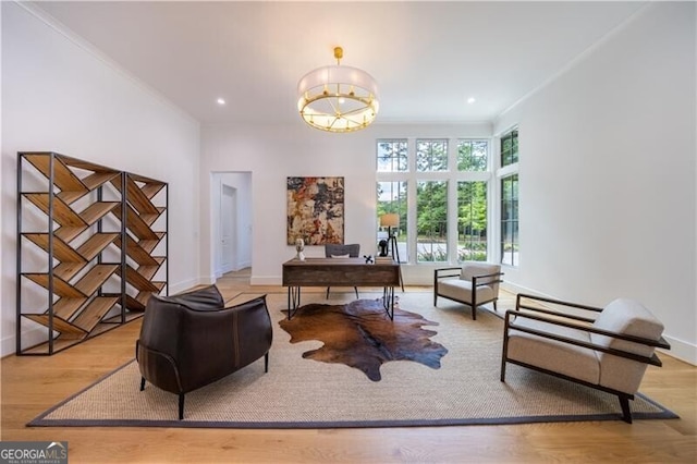 home office with light wood-type flooring and ornamental molding