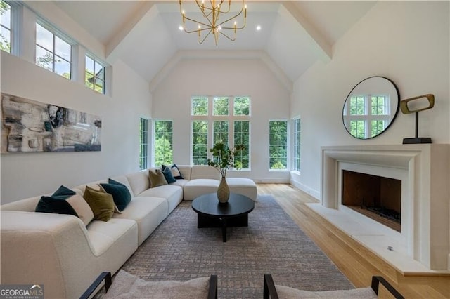 living room featuring a notable chandelier, light hardwood / wood-style floors, and a towering ceiling