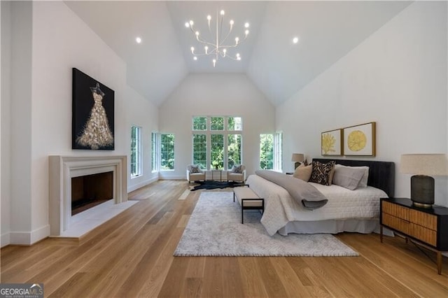 bedroom with high vaulted ceiling, light wood-type flooring, and an inviting chandelier