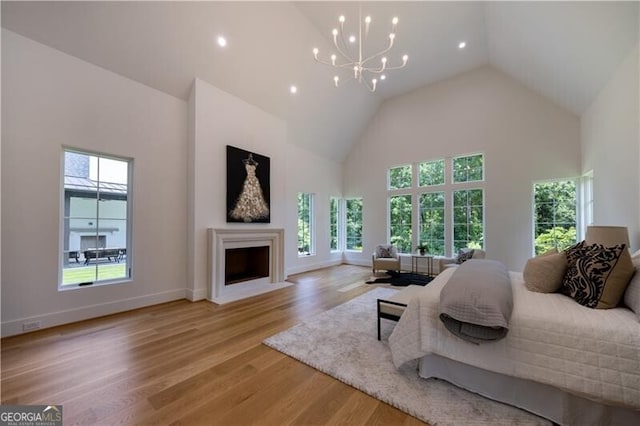 bedroom with light hardwood / wood-style flooring, high vaulted ceiling, and a chandelier