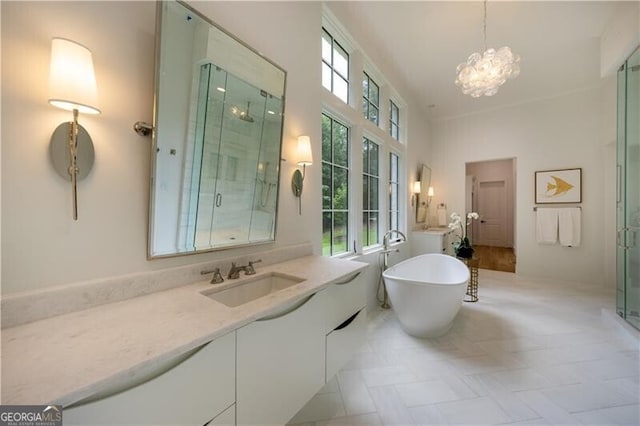 bathroom with an inviting chandelier, a towering ceiling, tile patterned floors, vanity, and plus walk in shower