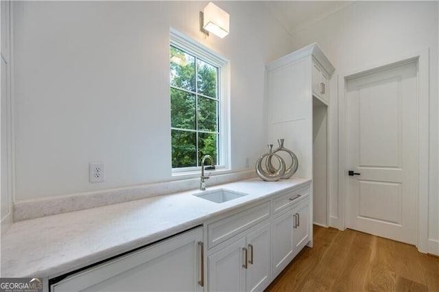 kitchen with sink, white cabinetry, and light hardwood / wood-style floors