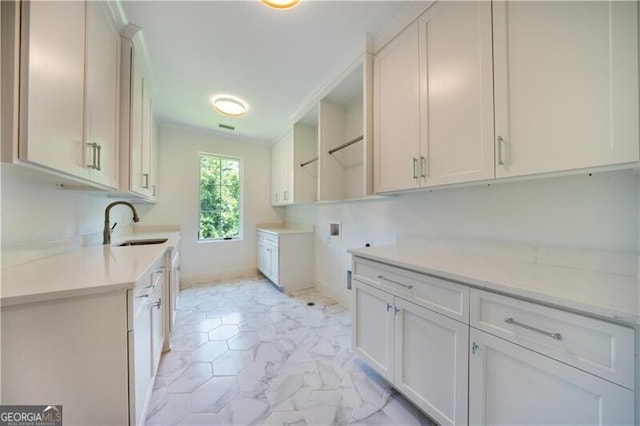 laundry room with sink, washer hookup, and cabinets