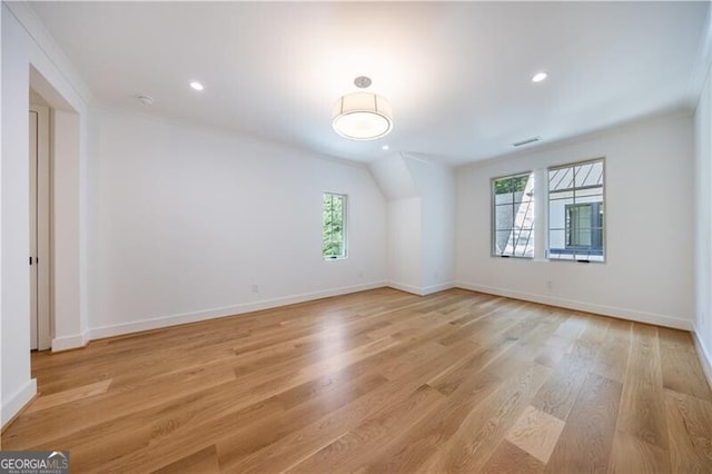 unfurnished room featuring light wood-type flooring and lofted ceiling