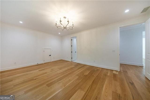 unfurnished room with ornamental molding, light hardwood / wood-style flooring, and an inviting chandelier