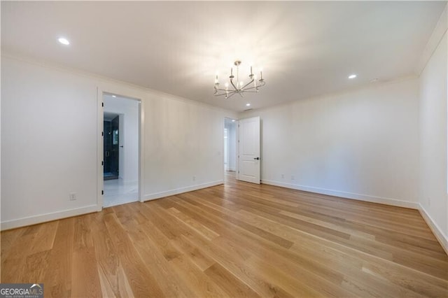 unfurnished room featuring ornamental molding, light hardwood / wood-style flooring, and a chandelier