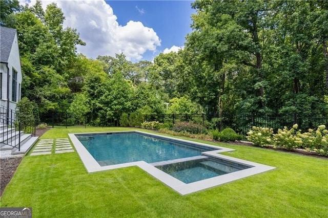 view of swimming pool with a yard and an in ground hot tub