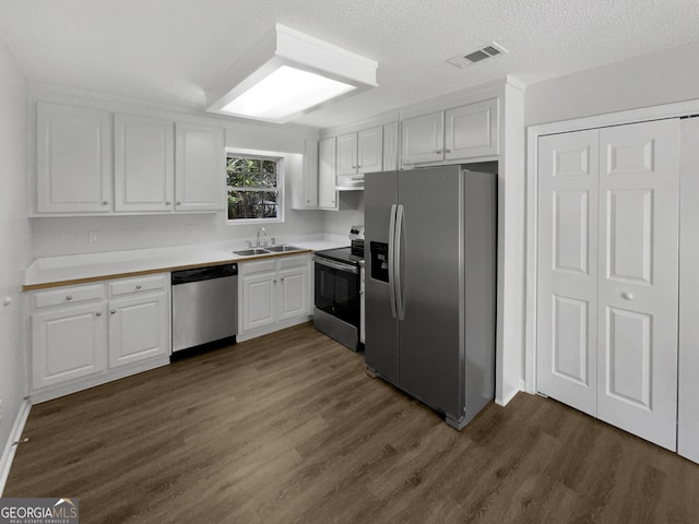 kitchen with sink, white cabinets, dark hardwood / wood-style flooring, and appliances with stainless steel finishes