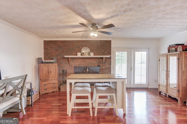 dining room with a textured ceiling, french doors, ornamental molding, dark wood-type flooring, and ceiling fan