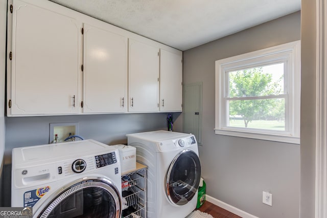 laundry room featuring cabinets, wood-type flooring, and washing machine and clothes dryer