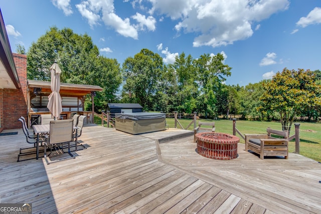 wooden terrace featuring a grill, a hot tub, and a fire pit