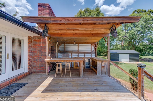 wooden deck with an outdoor structure and french doors