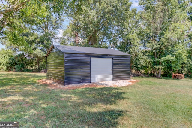 view of outdoor structure featuring a garage and a lawn