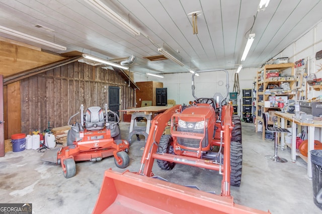 garage with wooden walls and a workshop area