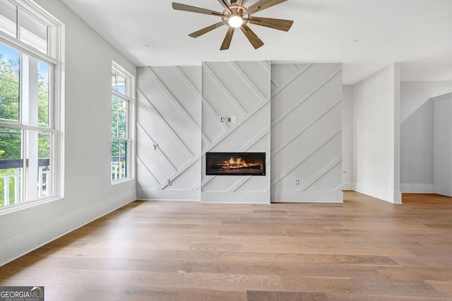 unfurnished living room with ceiling fan and light wood-type flooring