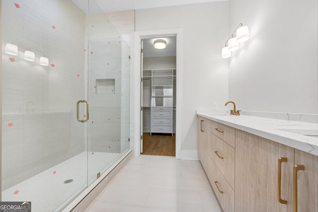 bathroom featuring walk in shower, tile patterned floors, and vanity