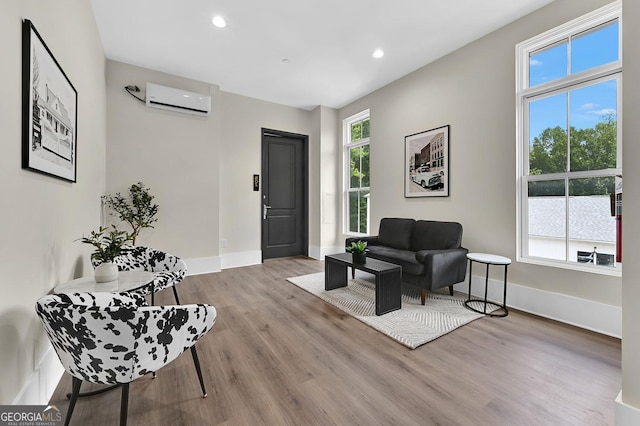 sitting room featuring a healthy amount of sunlight, light hardwood / wood-style floors, and a wall unit AC