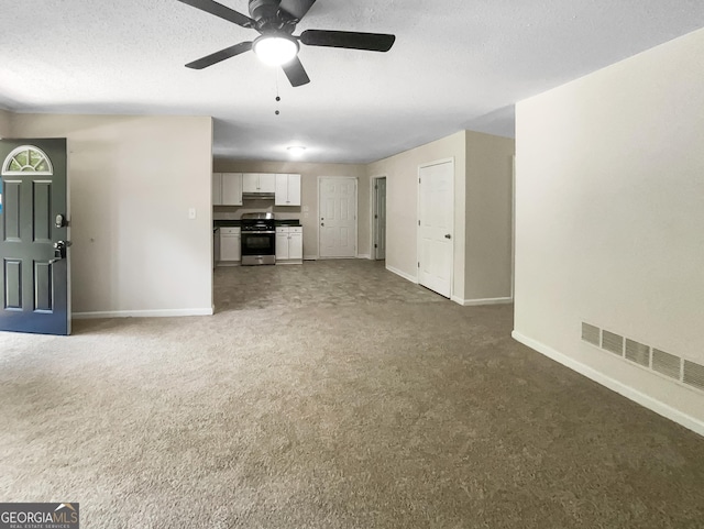 unfurnished living room with ceiling fan and dark carpet