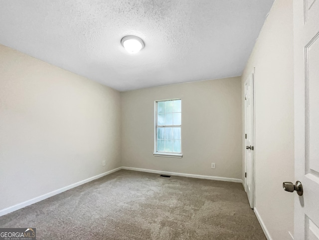 unfurnished room featuring a textured ceiling and carpet flooring