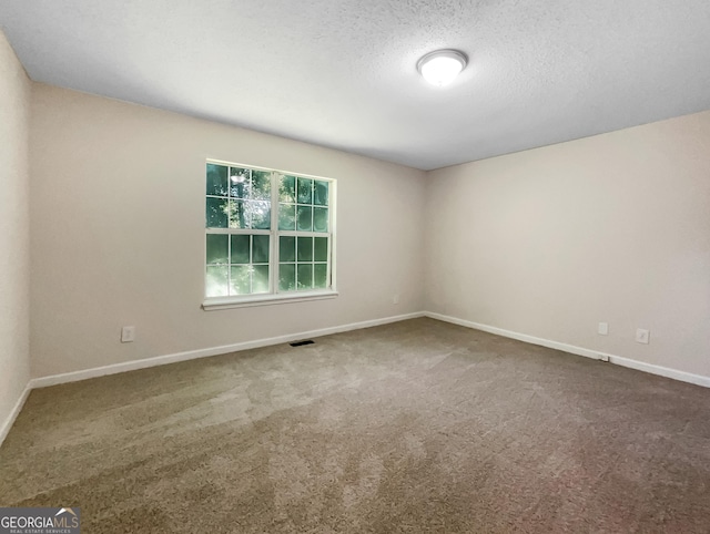 carpeted spare room with a textured ceiling