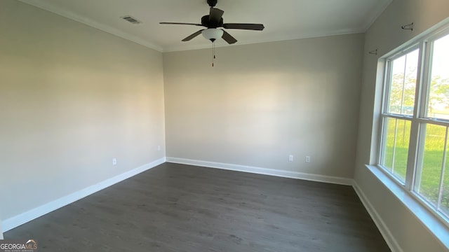 spare room featuring dark hardwood / wood-style flooring, ornamental molding, a wealth of natural light, and ceiling fan