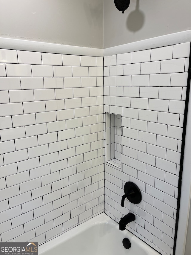 bathroom featuring tiled shower / bath