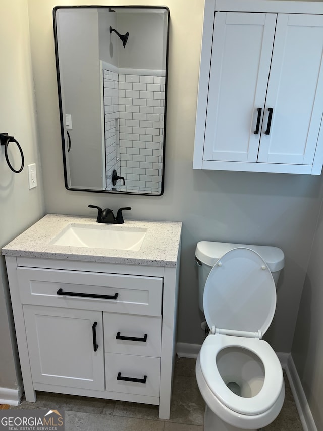 bathroom featuring vanity, tile patterned flooring, and toilet