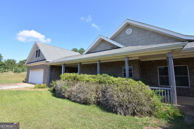 view of home's exterior featuring a porch, a garage, and a lawn