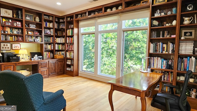 home office featuring light hardwood / wood-style flooring and crown molding