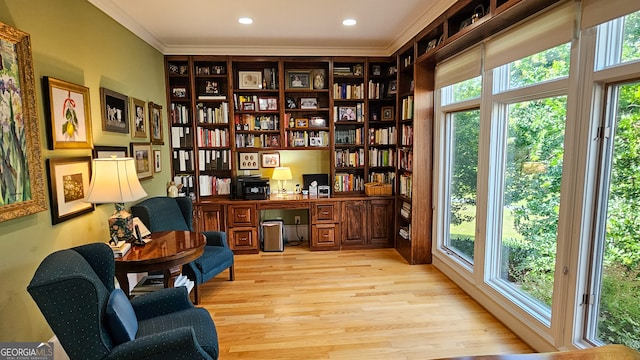 sitting room featuring built in desk, a healthy amount of sunlight, and light wood-type flooring