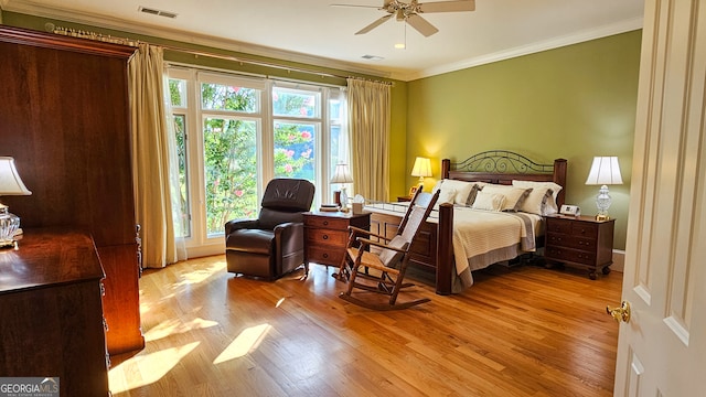 bedroom with ceiling fan, crown molding, and light hardwood / wood-style floors