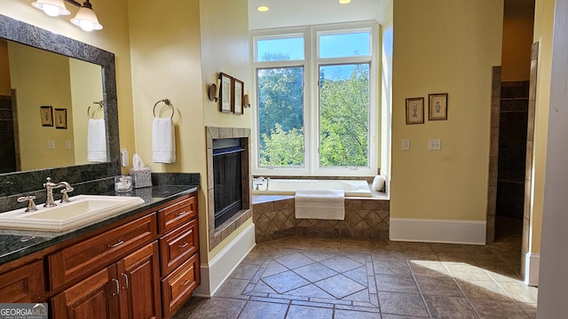 bathroom with vanity, plenty of natural light, and tiled tub