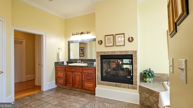 bathroom with vanity, tiled bath, ornamental molding, and a multi sided fireplace