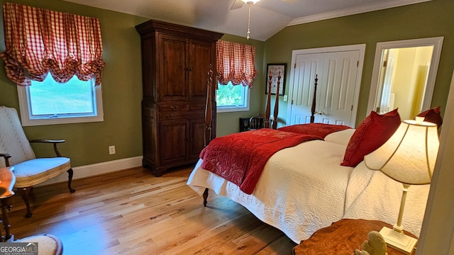 bedroom with light hardwood / wood-style flooring, multiple windows, vaulted ceiling, and ceiling fan