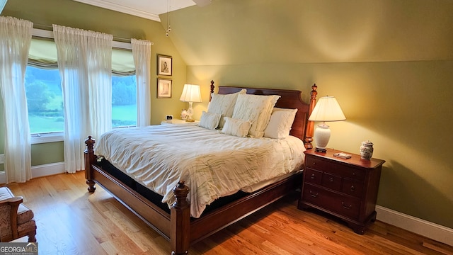 bedroom featuring vaulted ceiling and light wood-type flooring