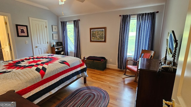 bedroom with vaulted ceiling, multiple windows, light hardwood / wood-style floors, and ceiling fan