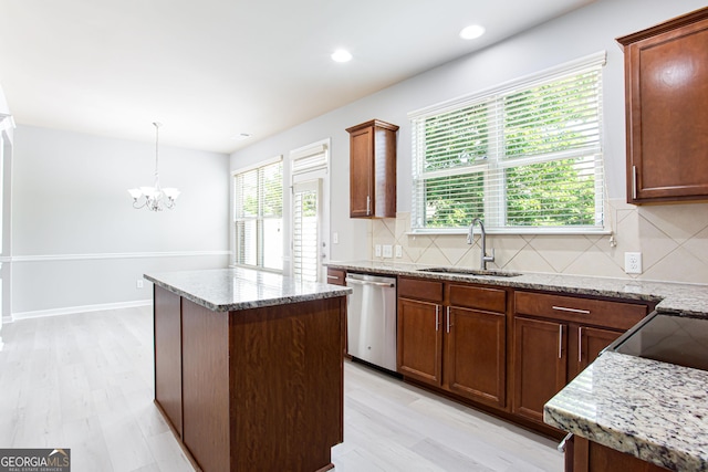 kitchen with sink, stainless steel dishwasher, backsplash, and a center island