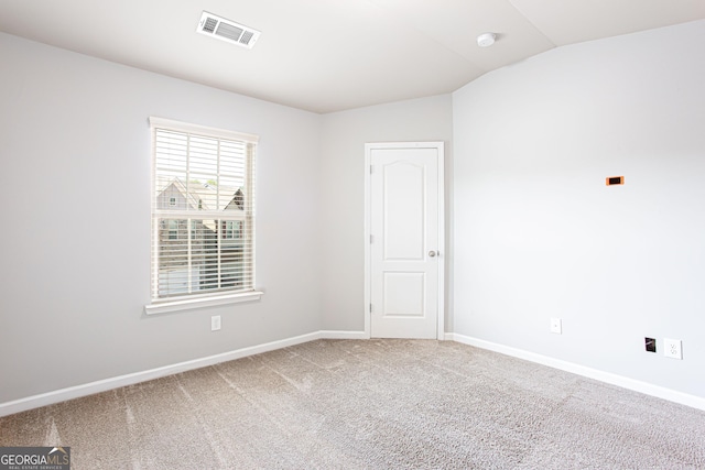 spare room featuring carpet and lofted ceiling