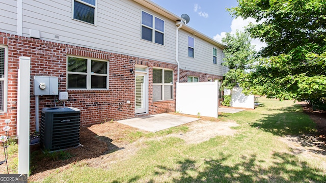 back of house with a lawn, central air condition unit, and a patio area