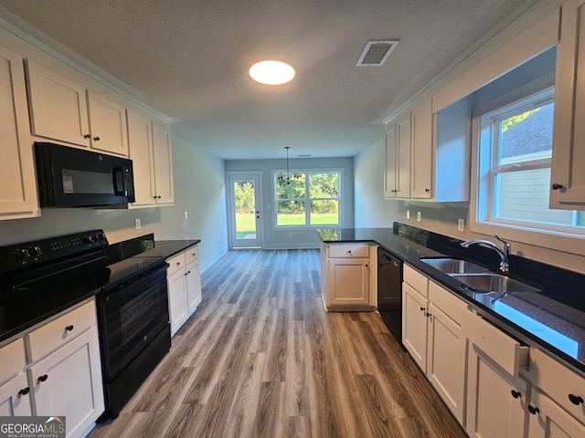 kitchen featuring white cabinets, pendant lighting, black appliances, hardwood / wood-style flooring, and sink