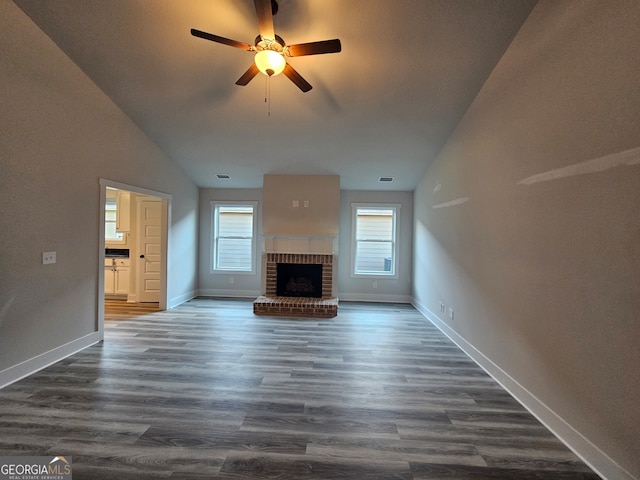 unfurnished living room with lofted ceiling, ceiling fan, dark hardwood / wood-style floors, and a fireplace