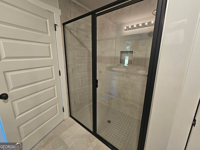 bathroom featuring a shower with door and tile patterned floors