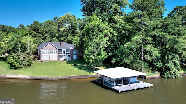 dock area featuring a water view, boat lift, stairs, and a yard