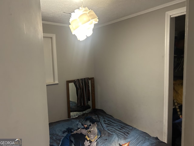 unfurnished bedroom featuring a textured ceiling and ornamental molding