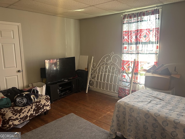 bedroom with dark wood-type flooring and a paneled ceiling