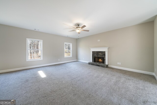 unfurnished living room with carpet floors, a fireplace, and ceiling fan