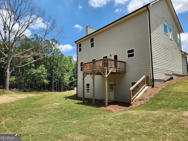 rear view of house featuring a wooden deck and a lawn