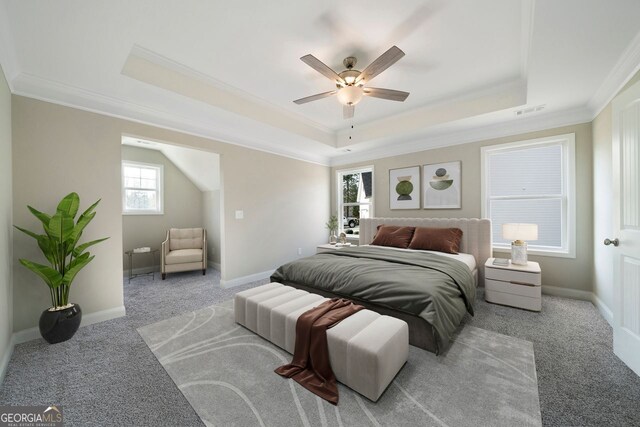 carpeted bedroom with ceiling fan, crown molding, and a tray ceiling