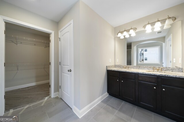 bathroom with tile patterned floors and dual bowl vanity